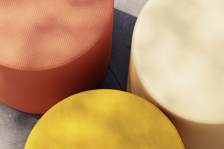 Top down view of three bumper ottomans upholstered in different textiles.