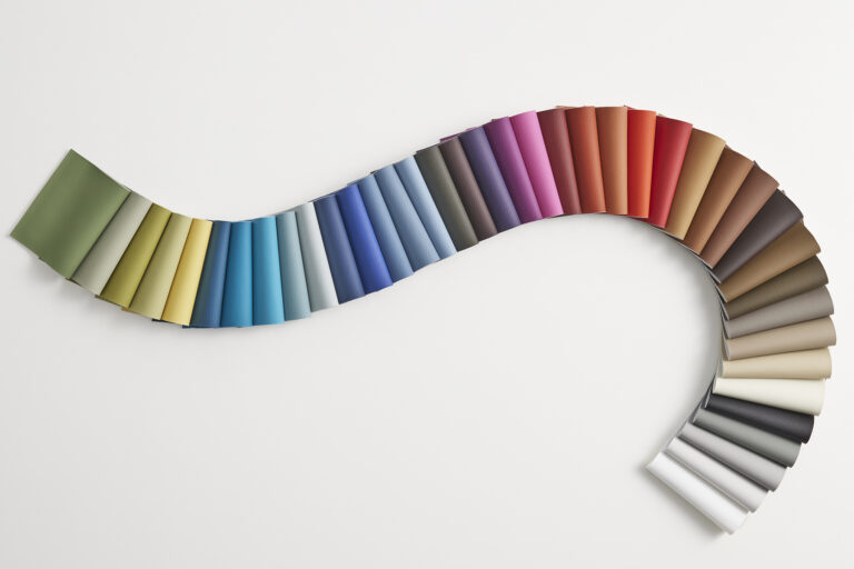 Snake of folded silicone samples arranged on a white table.