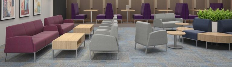 A corporate cafe, lounge area with banquette seating and sofas with wooden ottomans.