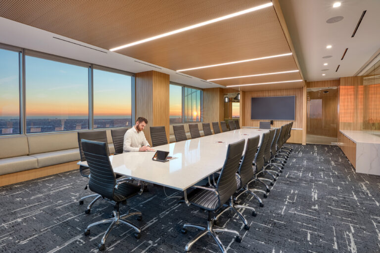 large conference room with one person sitting at a long conference table